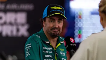 SINGAPORE, SINGAPORE - OCTOBER 02: Fernando Alonso of Spain and Aston Martin F1 Team talks to the